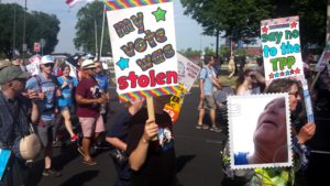 A person holding up a sign that says " my vote was stolen ".