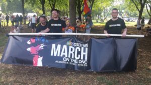 A group of people standing around a fence.