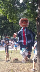 A man with glasses and tie is standing in the grass.